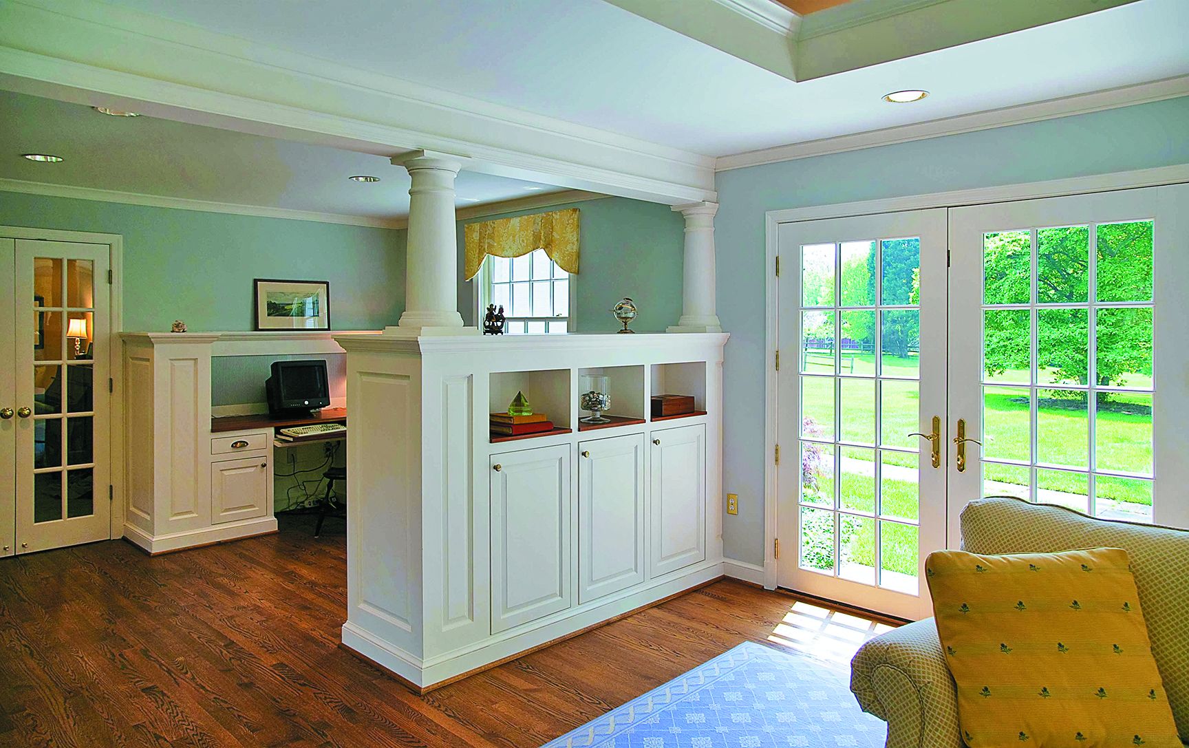 A room divider beneath a column with built in storage.