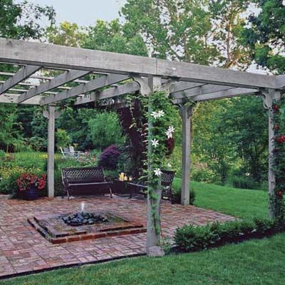 A brick patio with a pergola overtop of it.