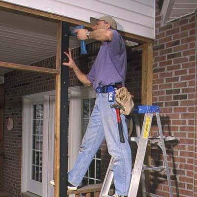 A man installs vertical base strips.