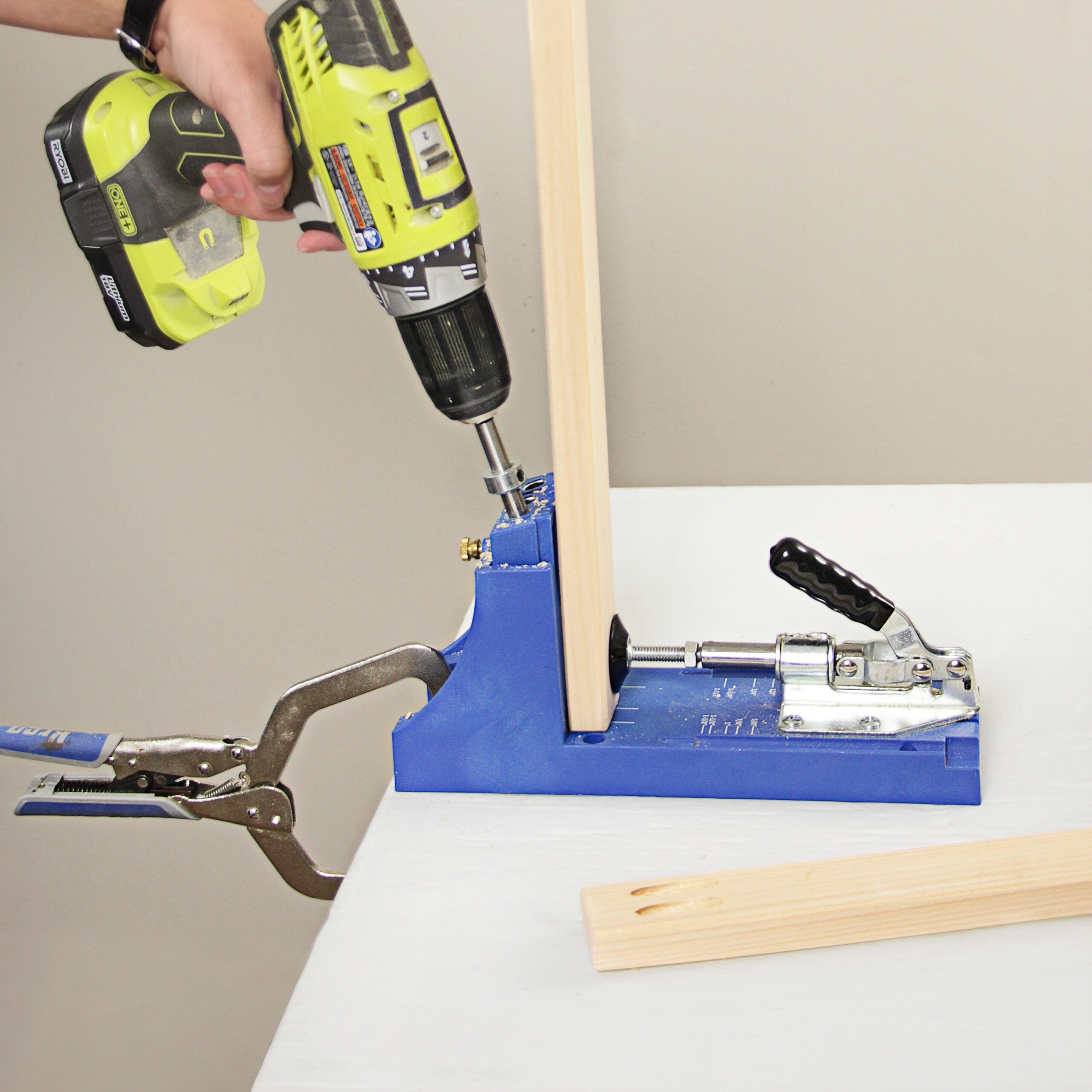 a pocket-hole jig is being used to drill angled holes into the coffee tables pieces