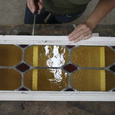 Image of a person installing a stained glass door on their DIY stylish bar cart