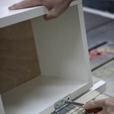 Image of a person installing hinges on their DIY stylish bar cart