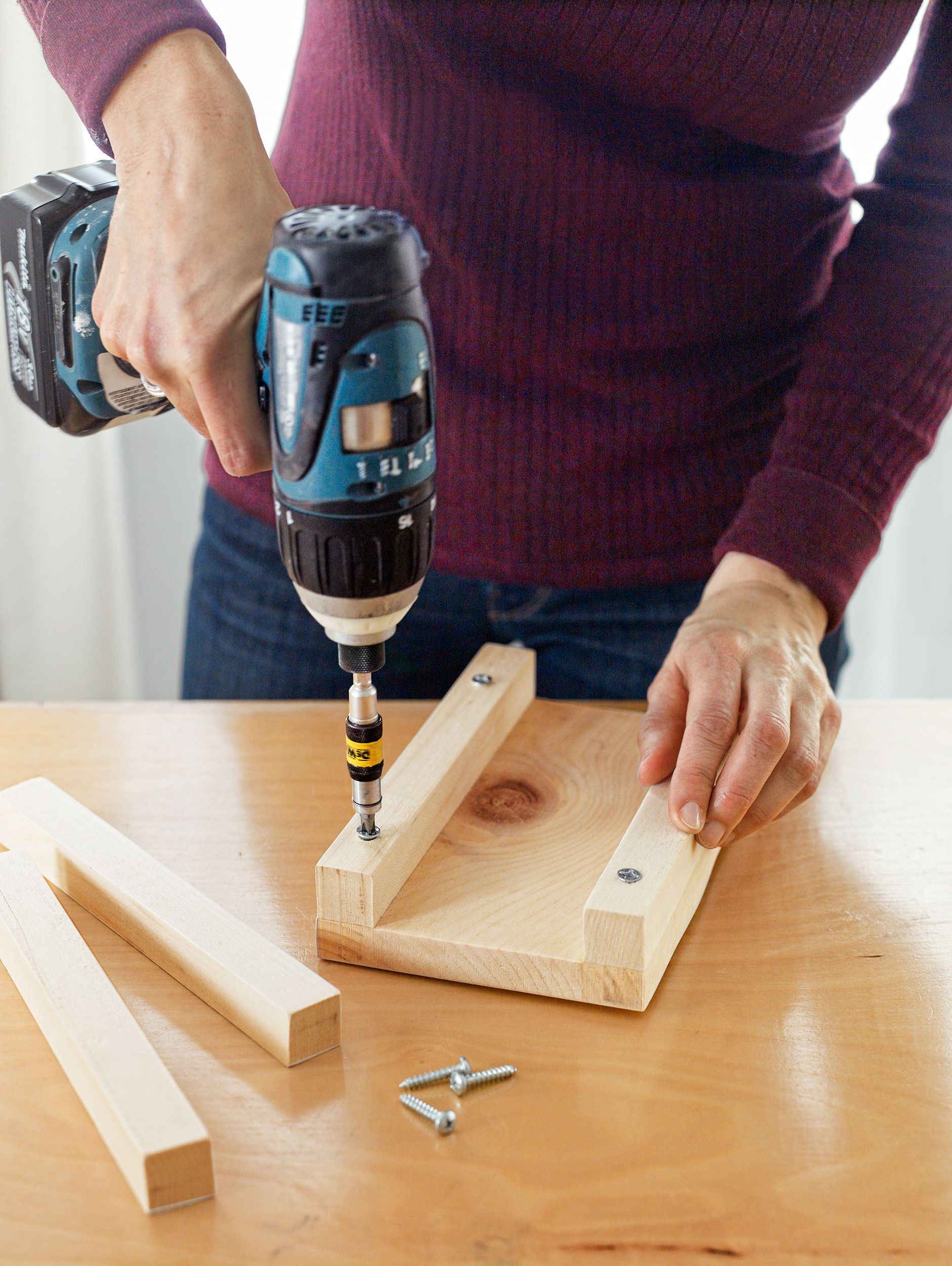 using an electric screwdriver to begin putting together a tin can lantern