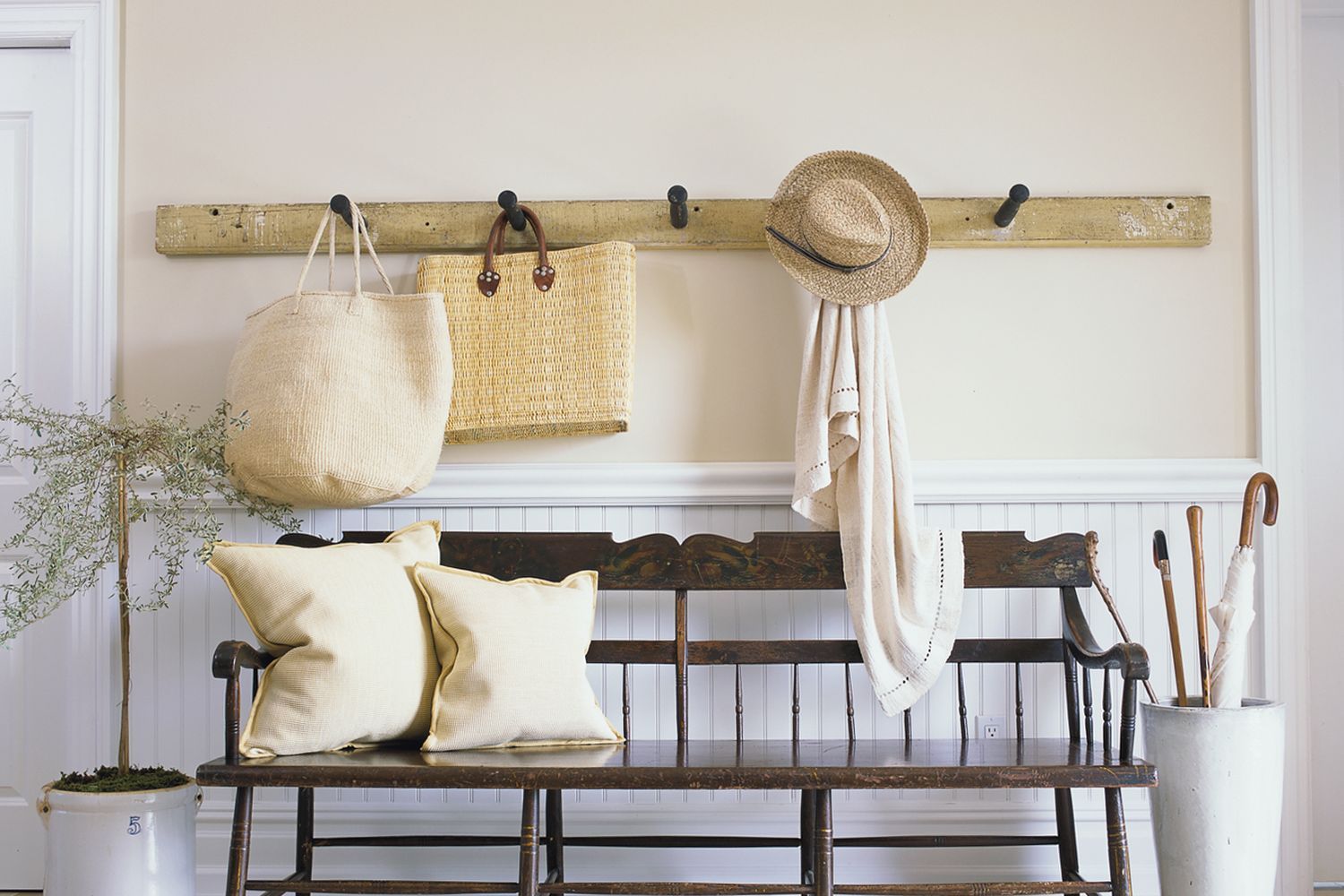 a bench, coat hooks, and umbrella stand