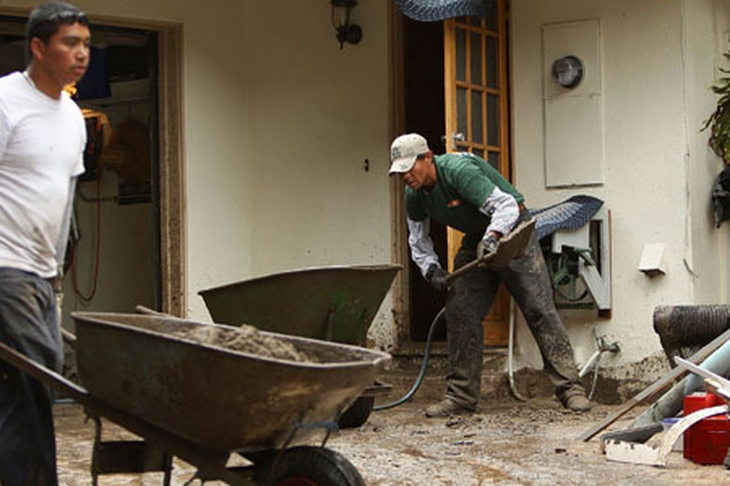 People cleaning up a home after a storm