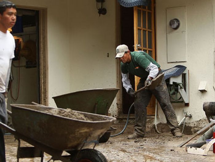 People cleaning up a home after a storm