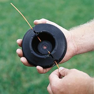 A plastic string being loaded into a string trimmer.