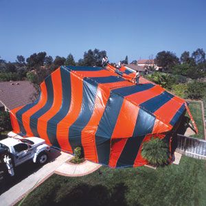 A termite infested house covered in fabric to be fumigated.