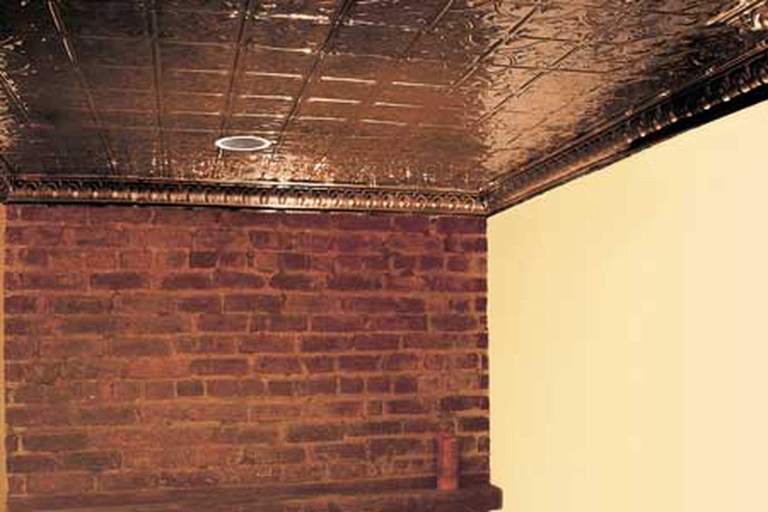 Room with a brick wall and tin ceiling