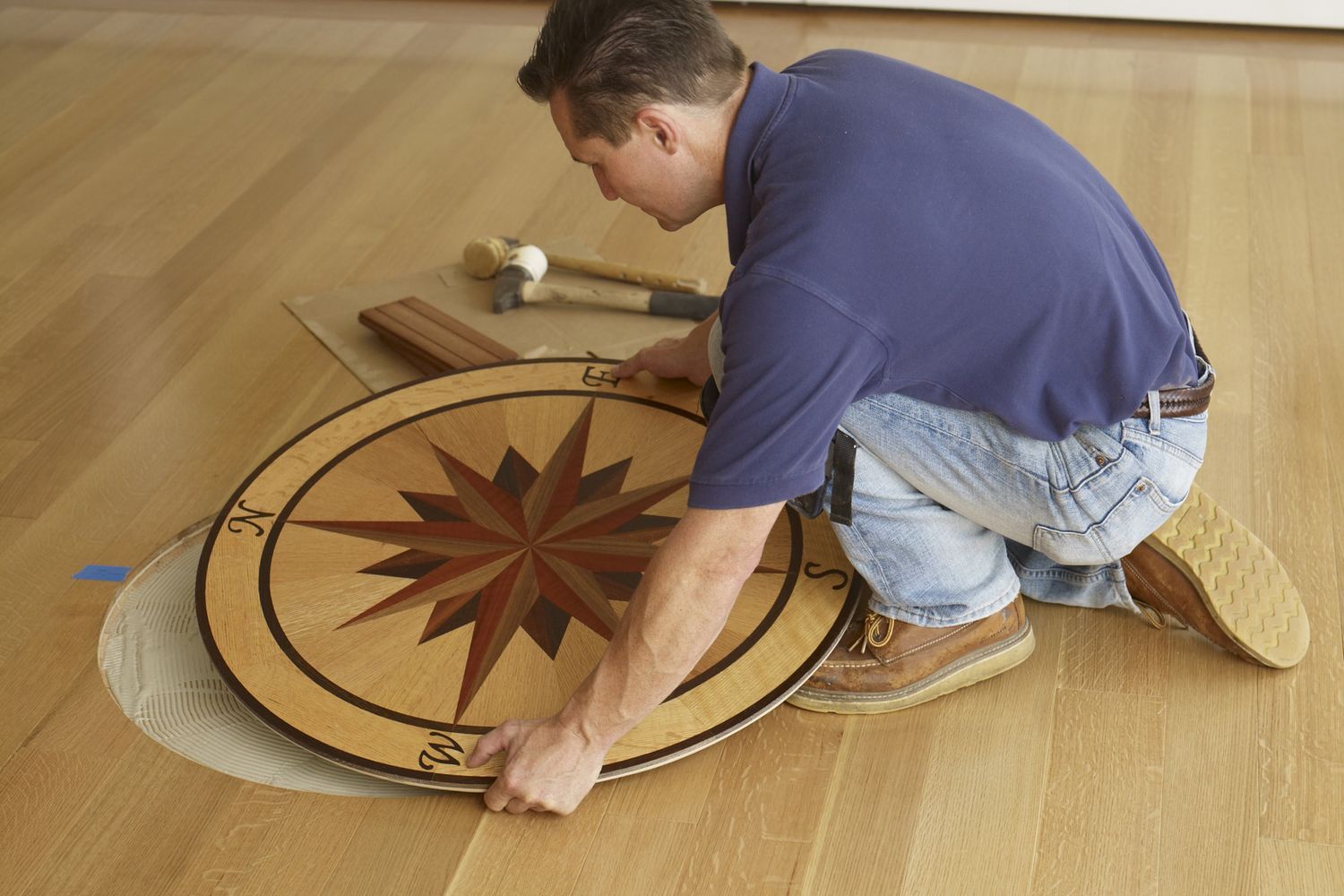 A homeowner installing a floor medallion