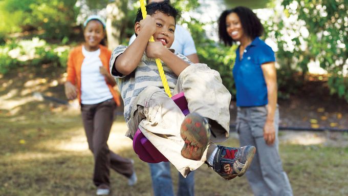 A child using a tree swing in a backyard.