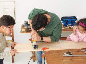 Man cutting wood pieces for step stool.