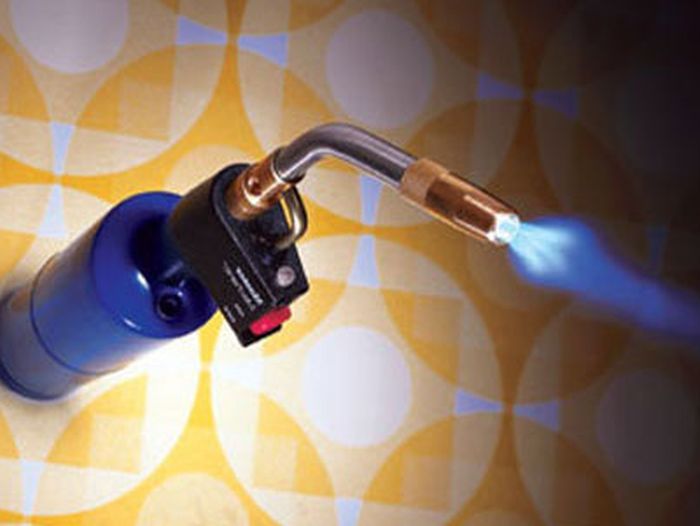 A torch sitting on a table releasing a blue flame.