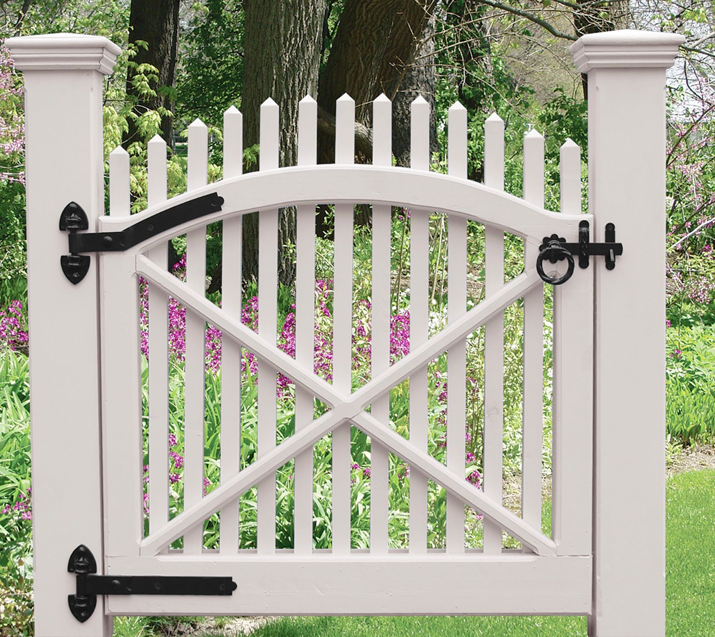 A picket fence containing a door with hinges.