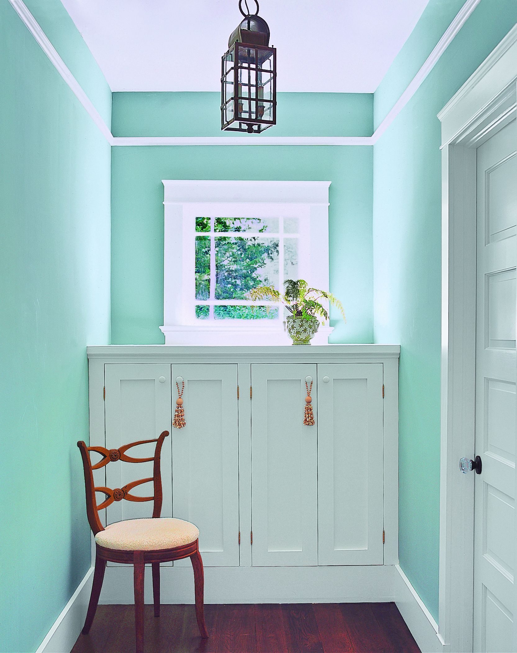 A storage cabinet sitting below a window.