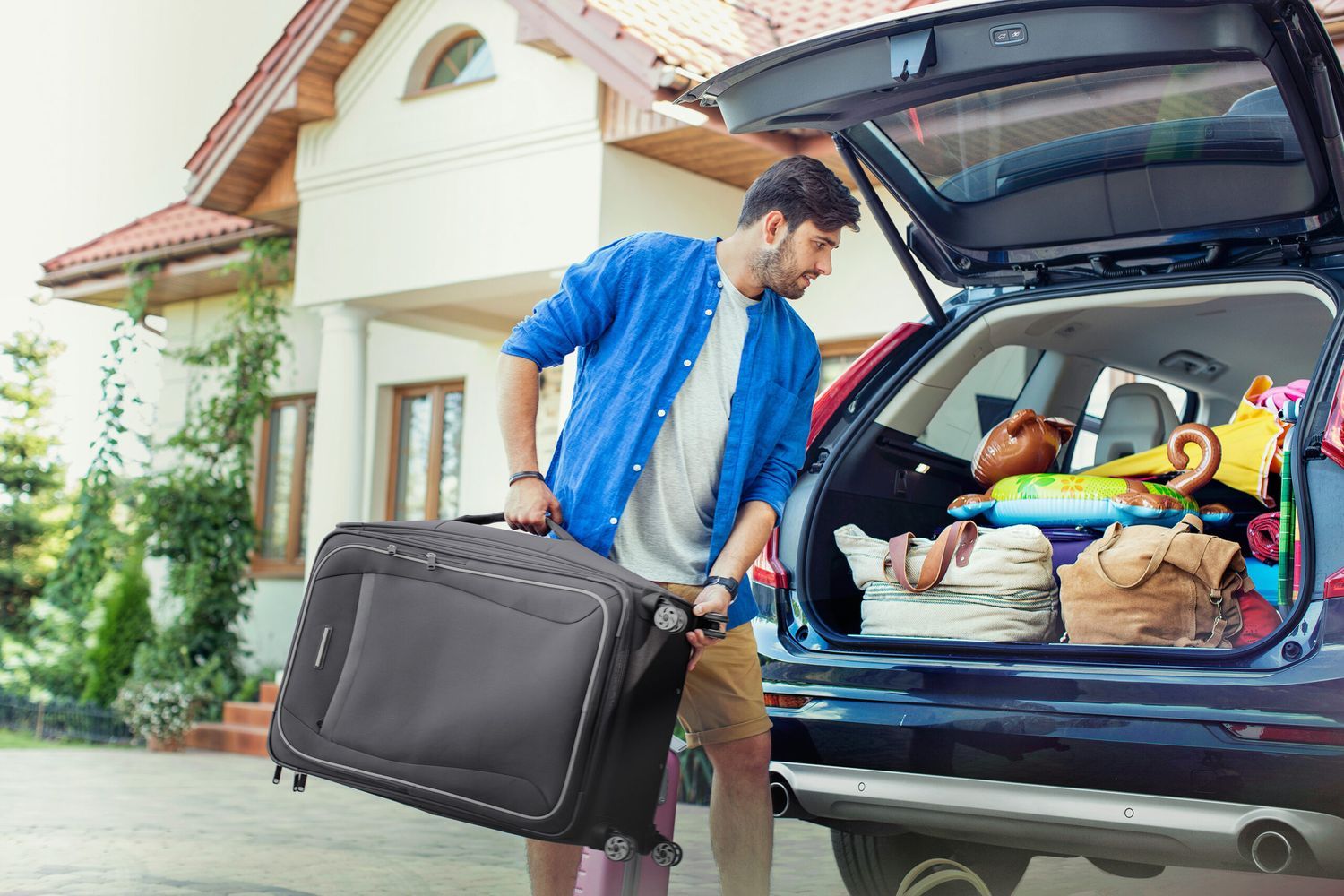 A man packing a car before going on vacation.