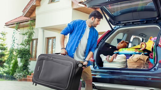 A man packing a car before going on vacation.