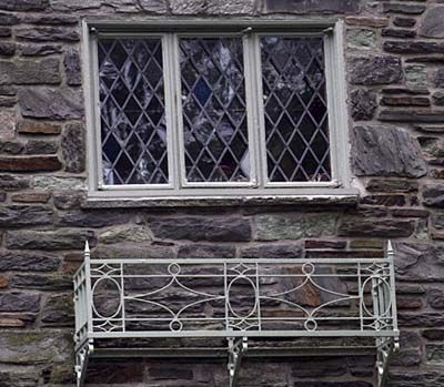 Victorian style casement windows on a home made of stone. 