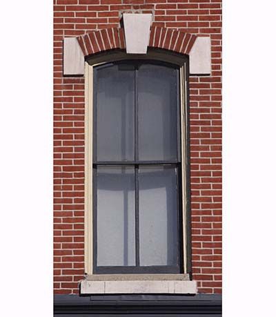 Italianate style window on a red brick home.