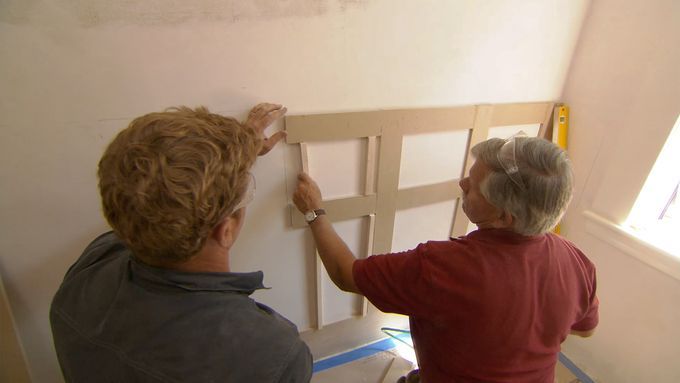 Two men working on wainscoting a bathroom