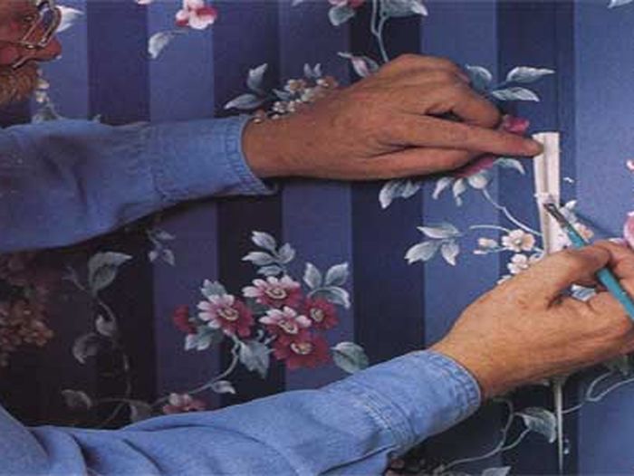 Someone repairing damaged wallpaper