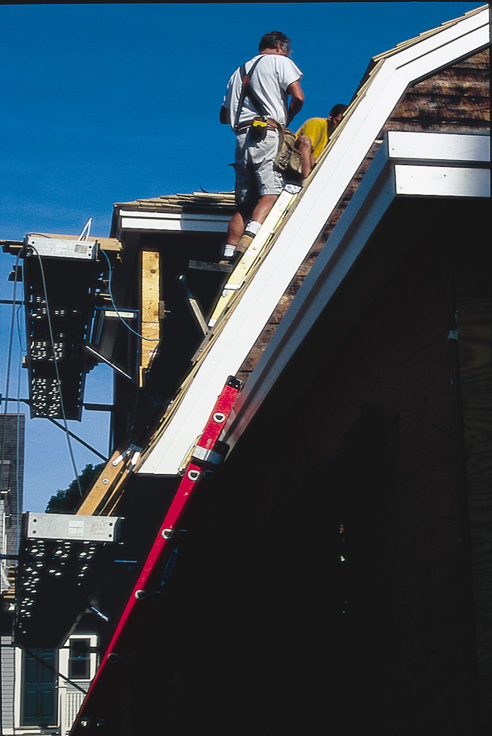 Photo of two roofing contractors replacing a shingle roof