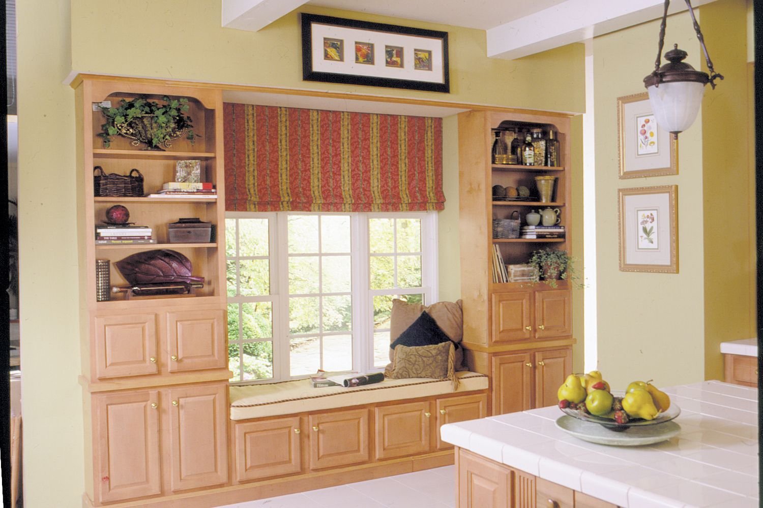 A cushioned window seat between two book cases.