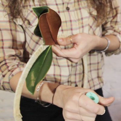 A woman building a wreath with thread.