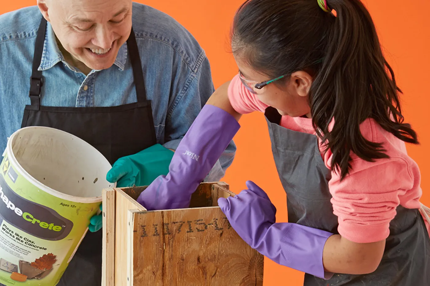a parent and child packing the form with concrete.