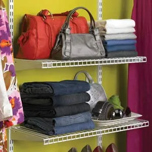 clothes and items resting on a wire shelf within a closet
