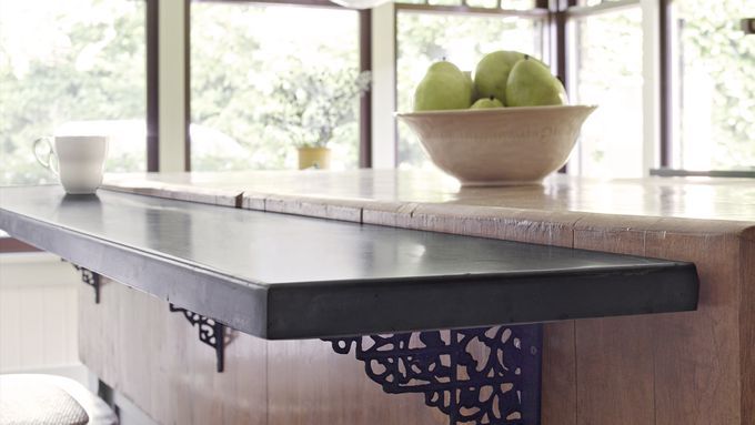 Mounted breakfast bar with brown countertop.