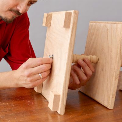 A man attaching the base to a tiered serving table.