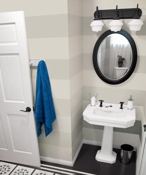 a bathroom that is painted with horizontal stripes on the wall