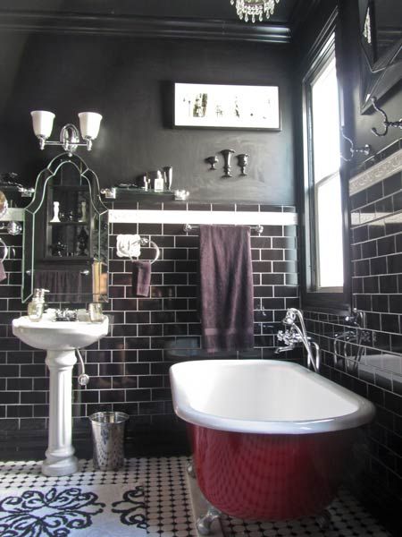 a bathroom that has black walls and a black and white floor