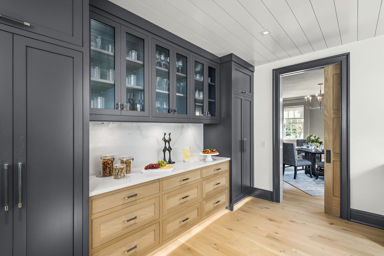A room with dark gray and light wood cabinets.