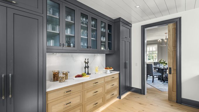 A room with dark gray and light wood cabinets.