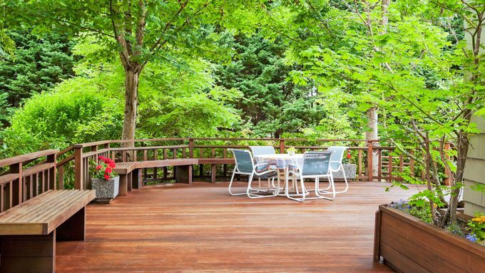 A wooden deck with several trees off to the sides.