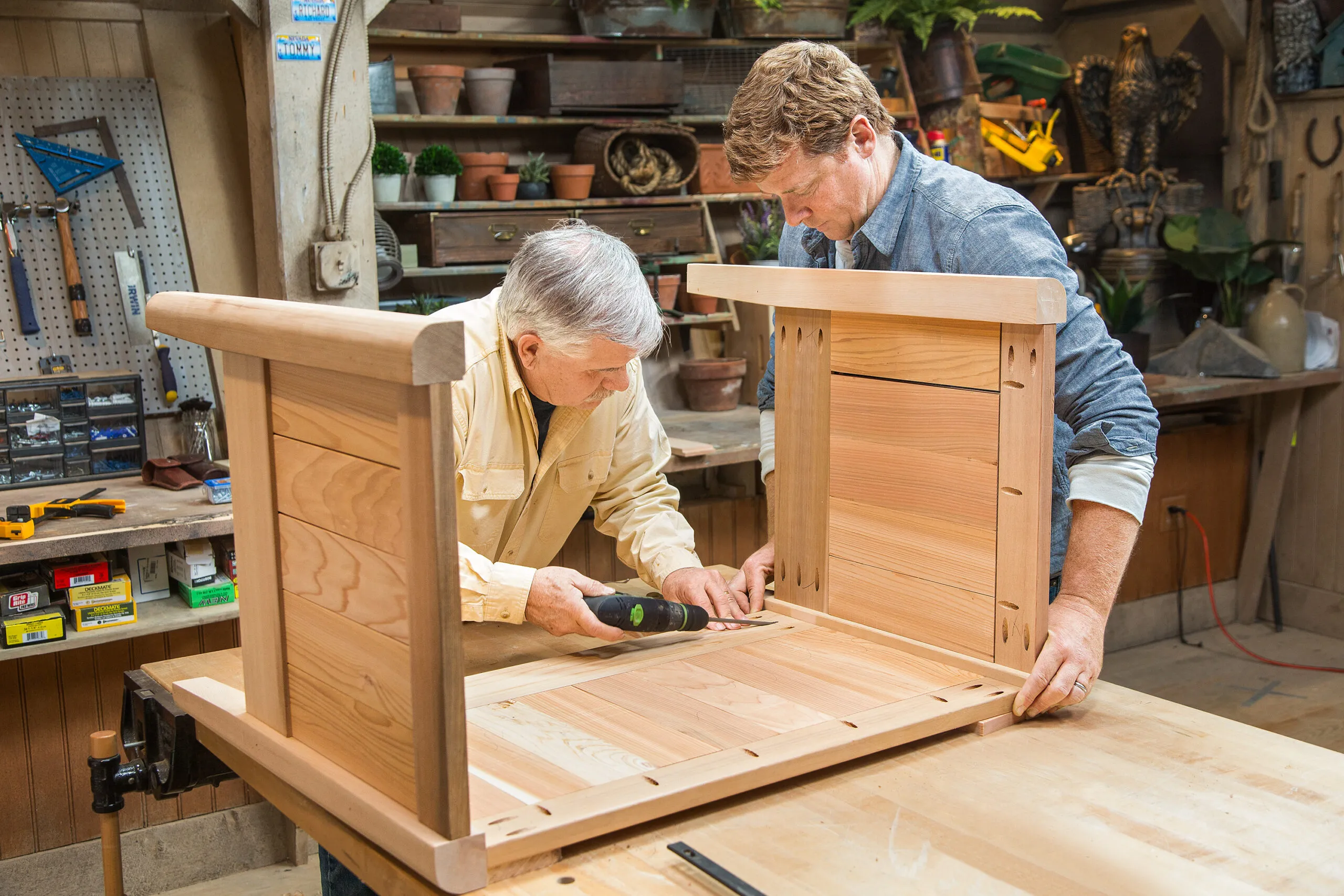 Tom Silva and Kevin O'Connor attach the sides of the cedar planter box.