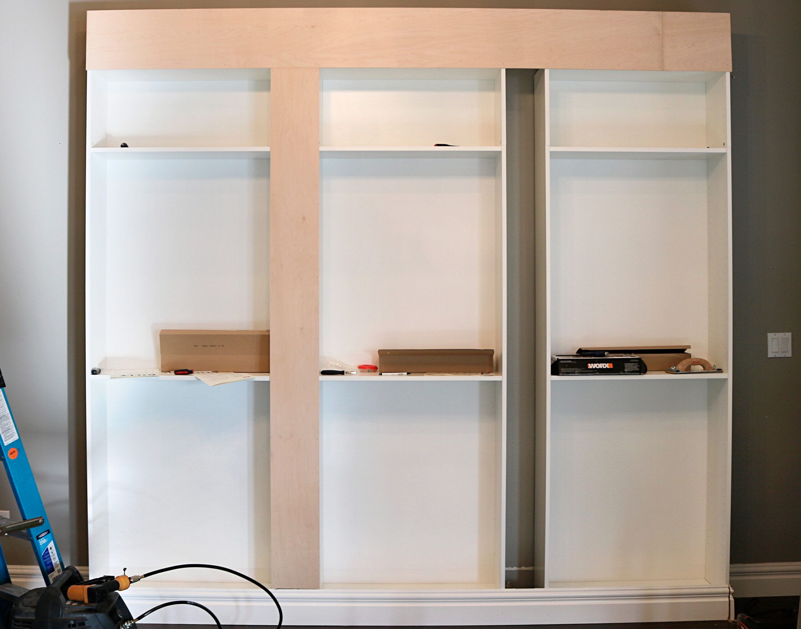 A wooden strip has been added in between two of the three bookcases to cover the gap and make them look like one unit.