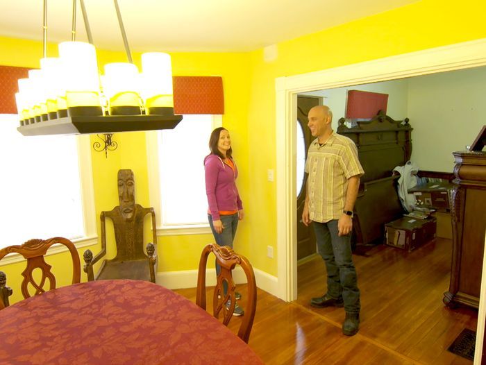 Two people standing in a room with an overhead light fixture.