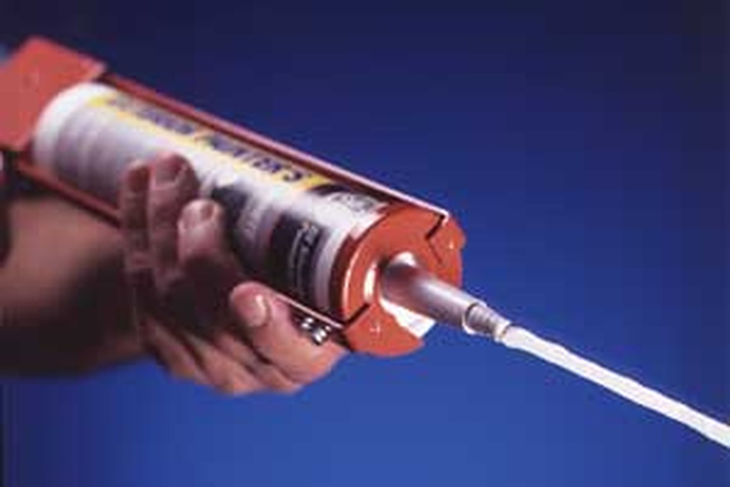 A caulk gun being used to lay a perfect bead of caulk.