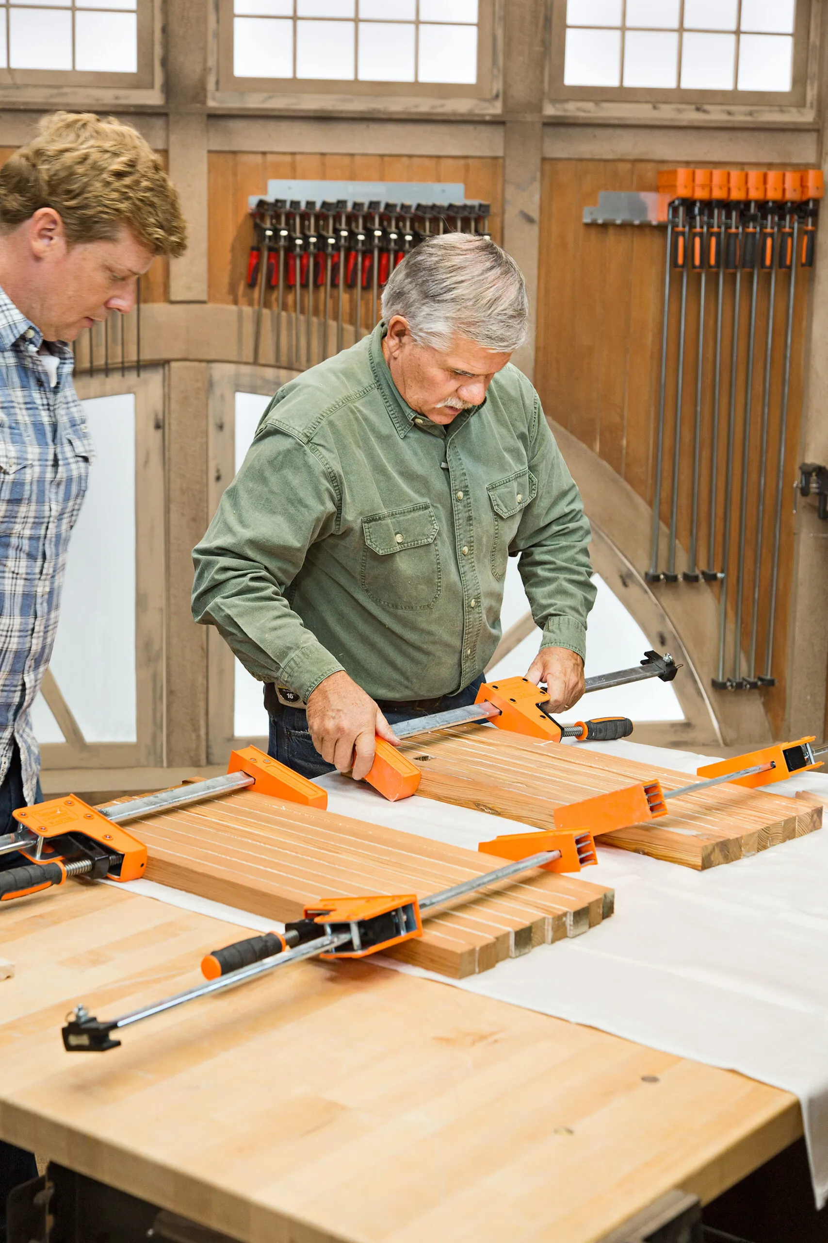 Two men are pictured working on an end grain cutting board.