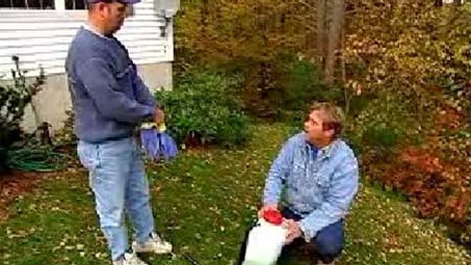 Two men preparing to deer proof a yards shrubs.