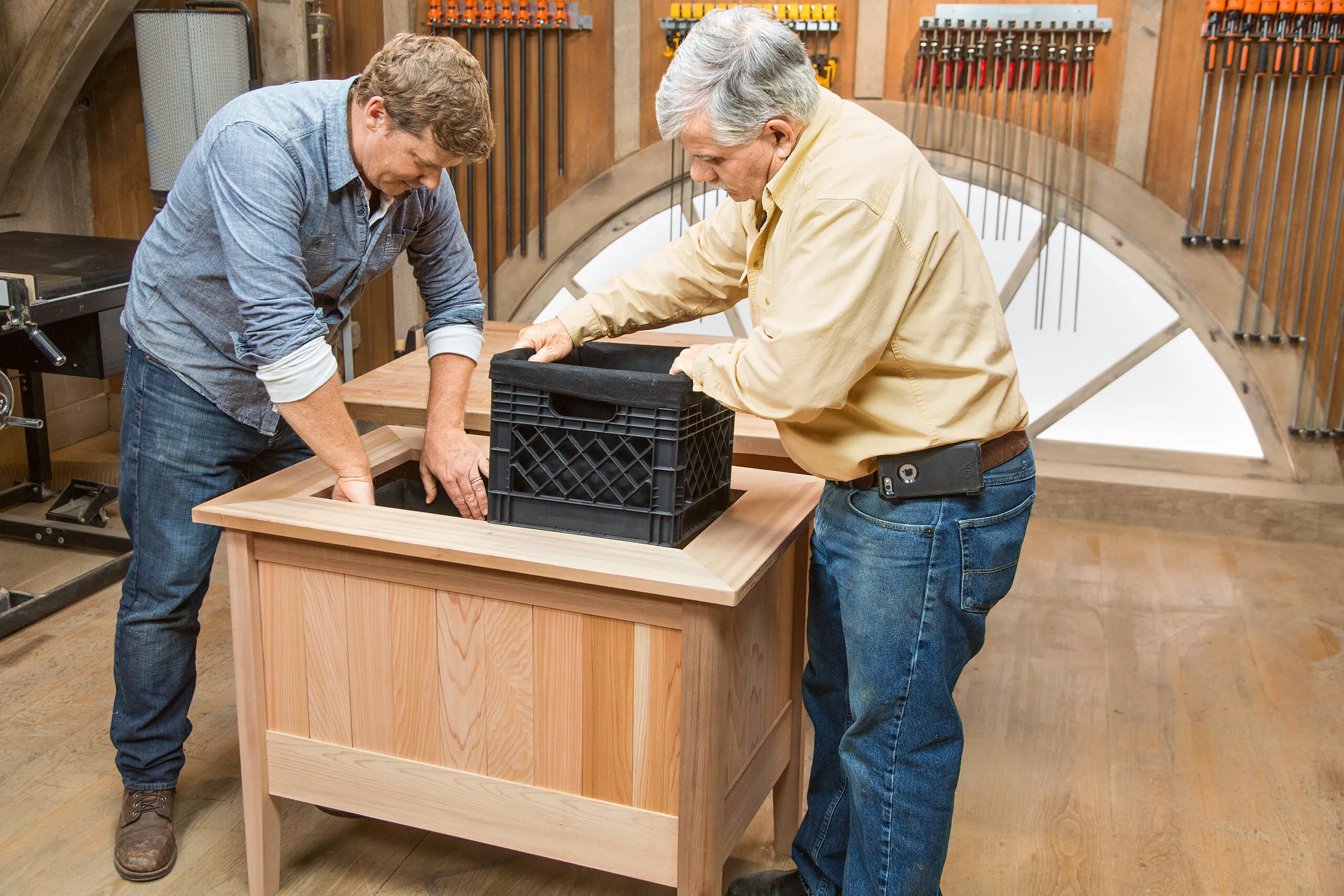Tom Silva and Kevin O'Connor place milk crates into the cedar planter box.