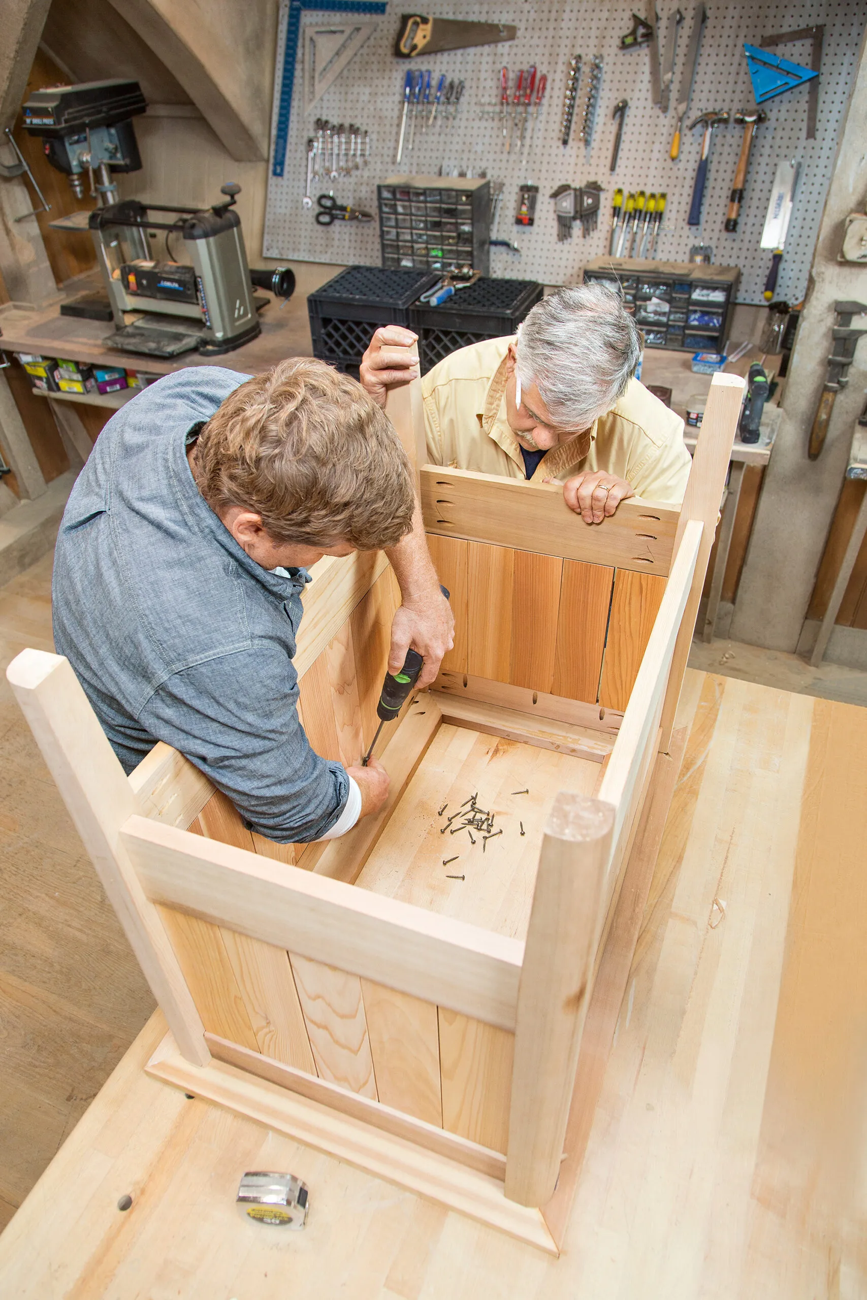 Tom Silva and Kevin O'Connor attach the top of the cedar planter box.