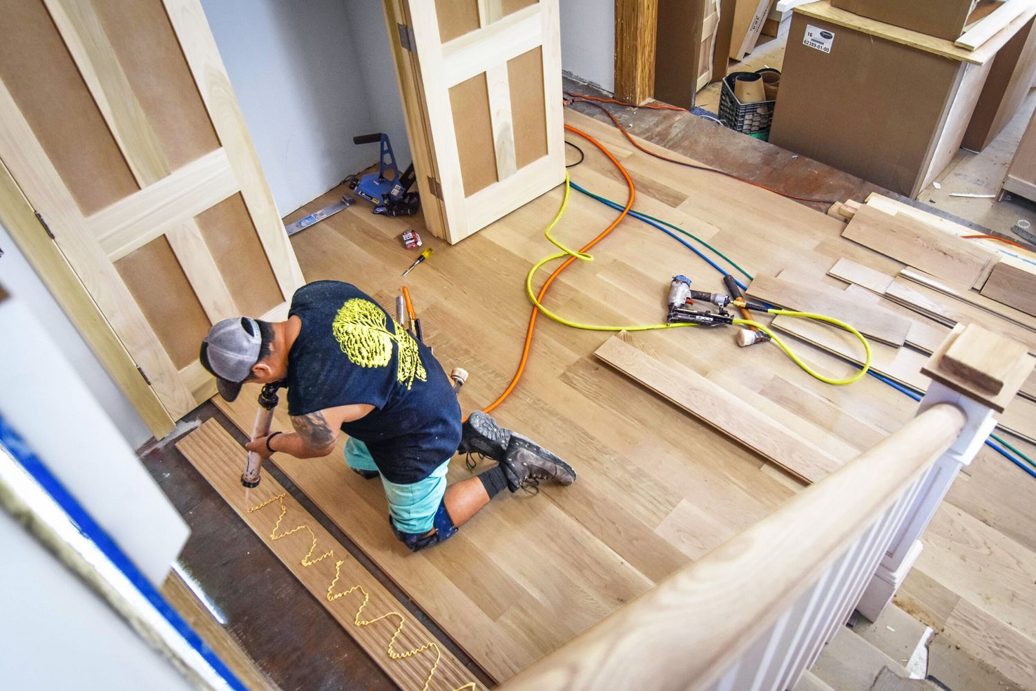 A contractor installing vinyl flooring over tile.