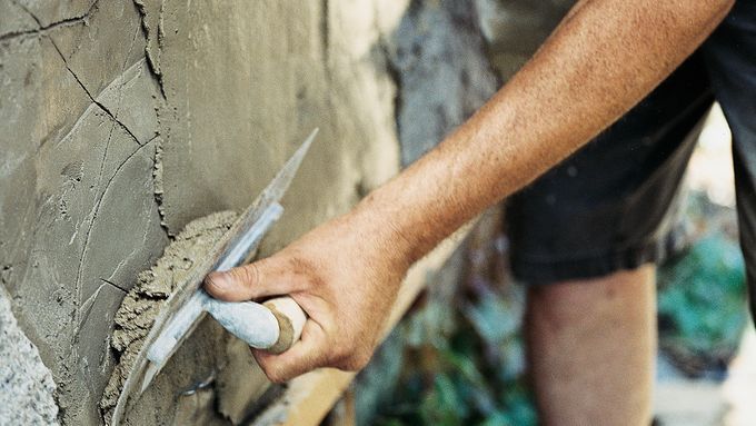 Stucco being applied to a wall to replace damaged stucco.