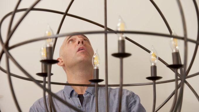 A man using a light lift to work with a high hanging fixture.