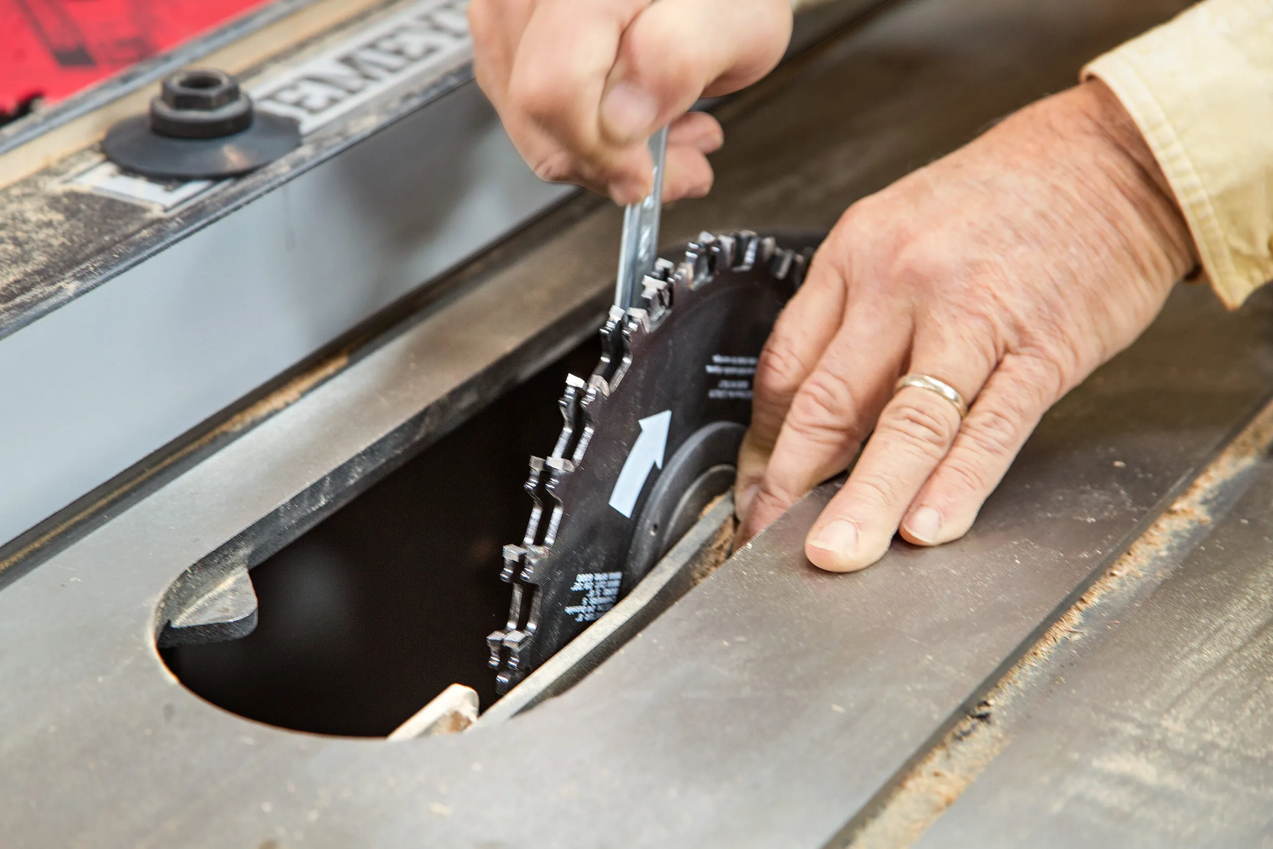 A person sets the dado blade to a precise ⅜-inch deep cut to begin cutting pieces for the cedar planter box.