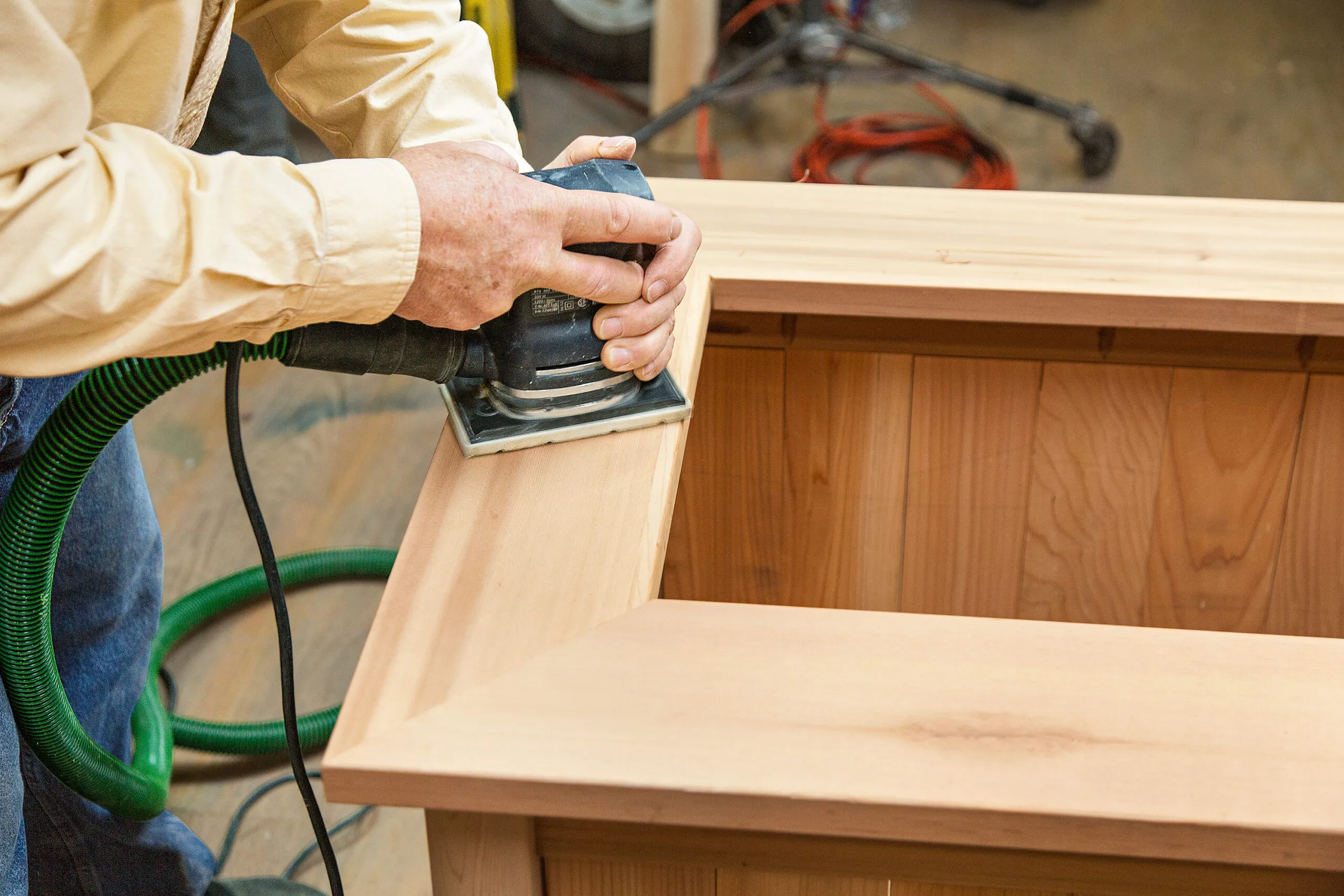 The top of the cedar planter box is sanded with a orbital sander.